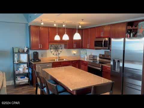 kitchen with a breakfast bar, decorative light fixtures, sink, and appliances with stainless steel finishes