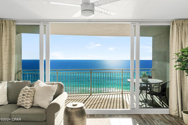 sunroom with ceiling fan, a water view, and a healthy amount of sunlight