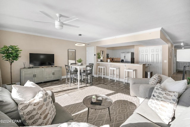 living room featuring light wood-type flooring, ceiling fan, and crown molding