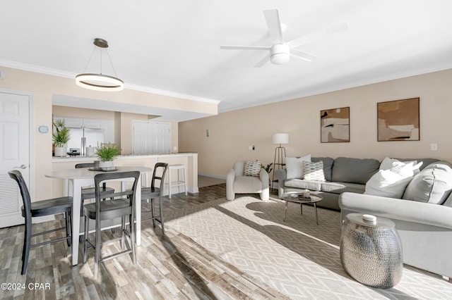 living room with ceiling fan, hardwood / wood-style flooring, and crown molding