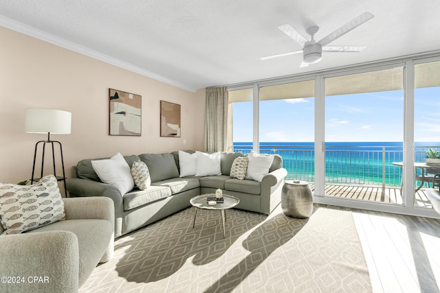 living room with floor to ceiling windows, a water view, and plenty of natural light