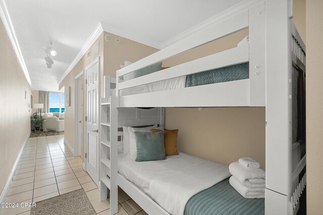 bedroom with light tile patterned floors and ornamental molding