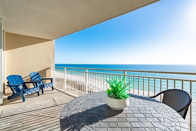 balcony with a water view and a view of the beach