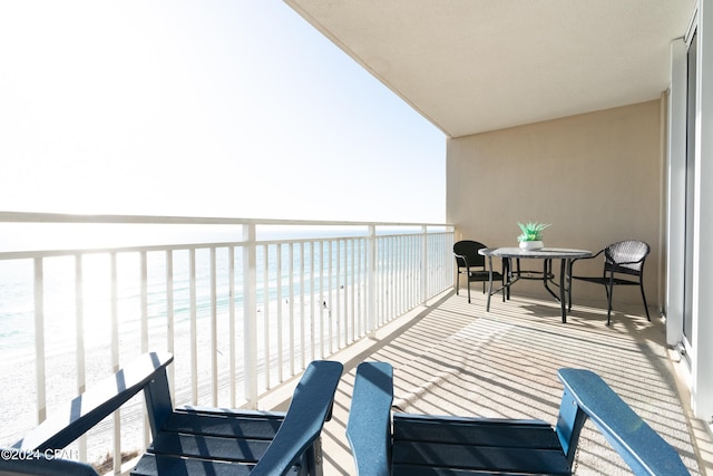 balcony featuring a water view and a beach view