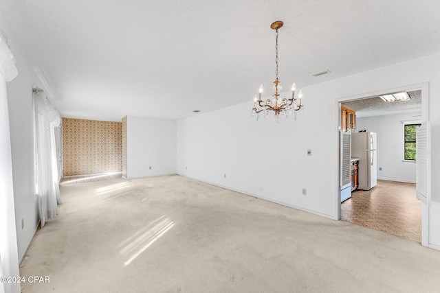 unfurnished room featuring carpet flooring and an inviting chandelier