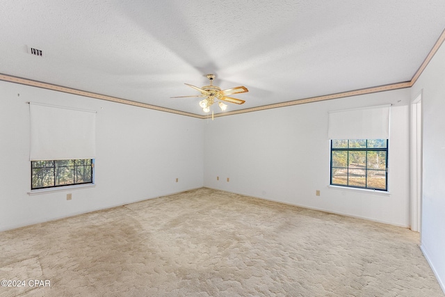 carpeted empty room with ceiling fan, a textured ceiling, and ornamental molding