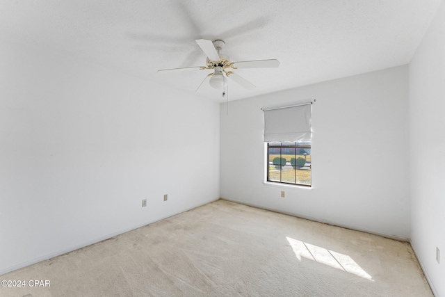 carpeted spare room featuring ceiling fan and a textured ceiling