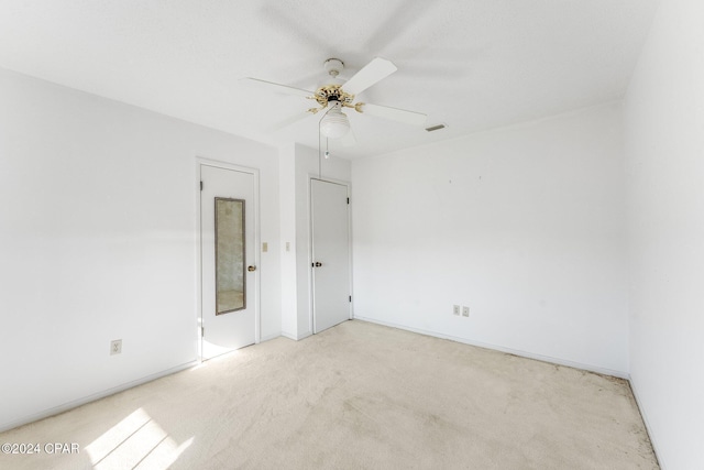 empty room with ceiling fan and light colored carpet