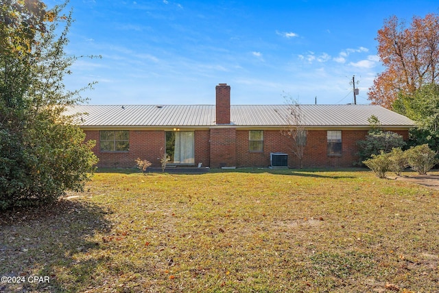 back of property featuring a lawn and central AC unit