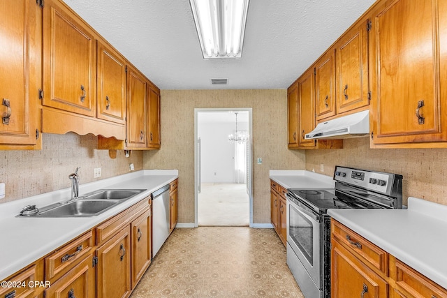 kitchen with a textured ceiling, stainless steel appliances, a notable chandelier, and sink