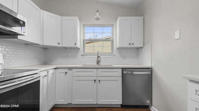 kitchen with backsplash, white cabinetry, sink, and stainless steel appliances