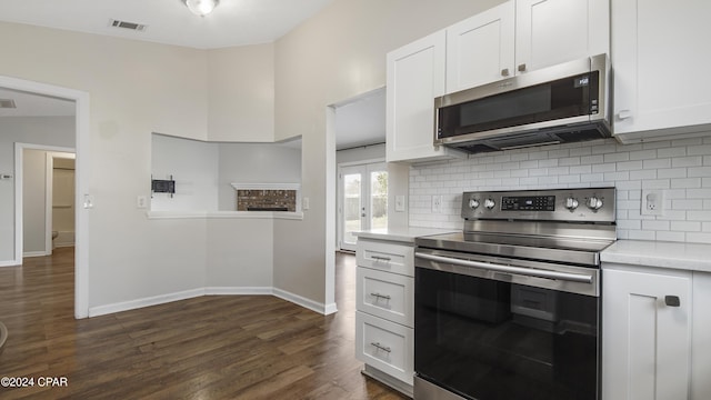 kitchen with decorative backsplash, dark hardwood / wood-style flooring, white cabinetry, and appliances with stainless steel finishes