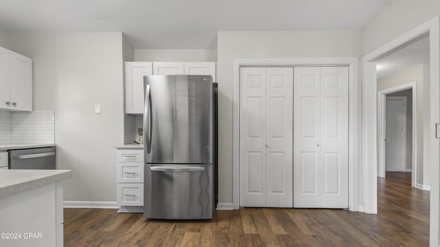 kitchen with white cabinets, dark wood-type flooring, appliances with stainless steel finishes, and tasteful backsplash