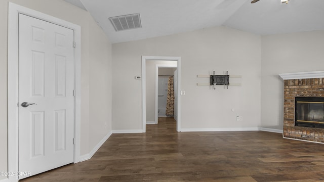 unfurnished living room with a fireplace, lofted ceiling, and dark wood-type flooring