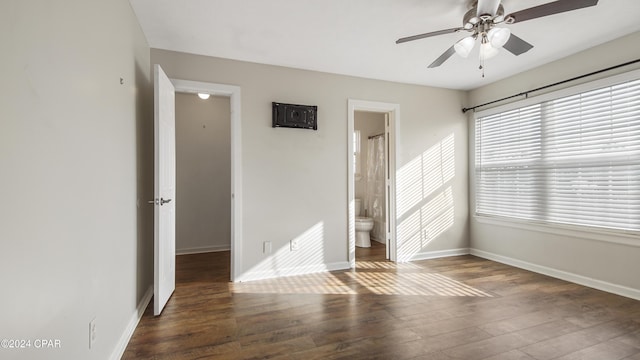 unfurnished bedroom featuring ceiling fan, dark hardwood / wood-style flooring, and connected bathroom