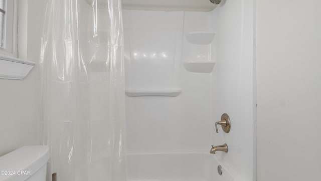 bathroom with shower / bath combo and toilet