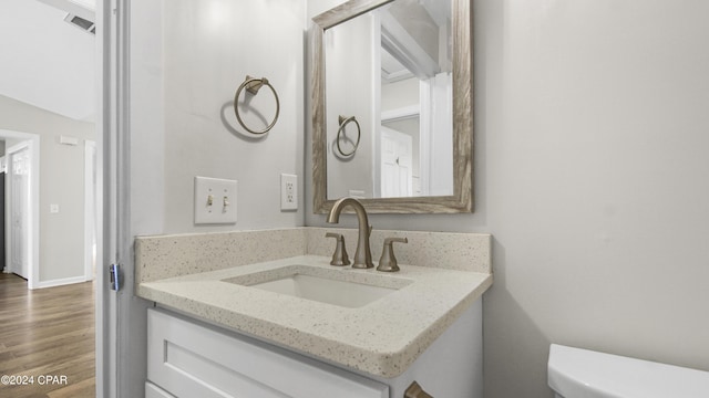 bathroom with hardwood / wood-style floors, vanity, and toilet