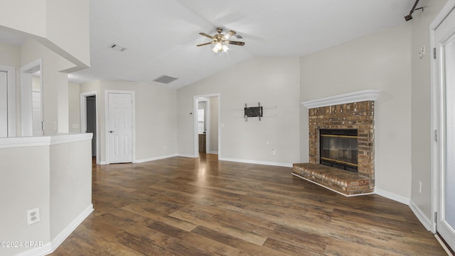 unfurnished living room with ceiling fan, lofted ceiling, dark wood-type flooring, and a brick fireplace