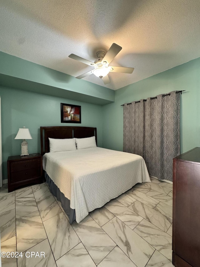 bedroom featuring ceiling fan and a textured ceiling