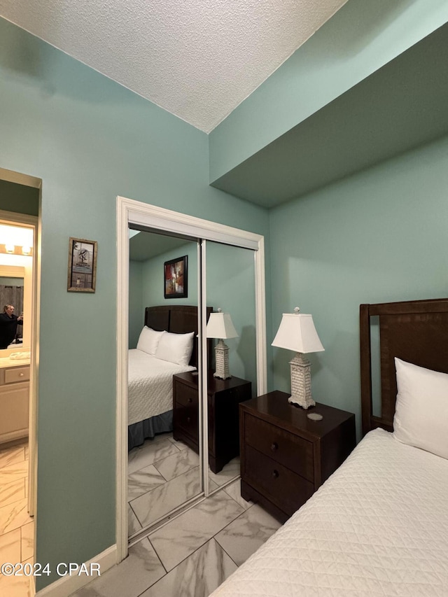 bedroom with a textured ceiling and a closet