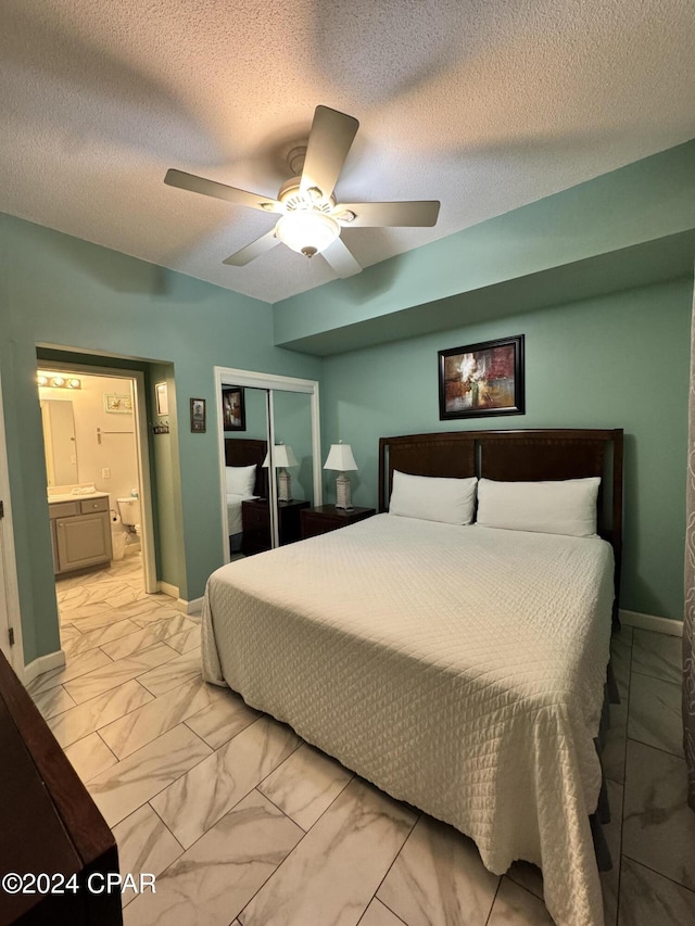 bedroom featuring ceiling fan, a closet, ensuite bathroom, and a textured ceiling