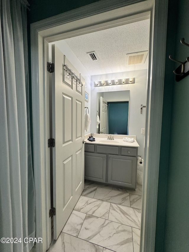 bathroom featuring a textured ceiling and vanity