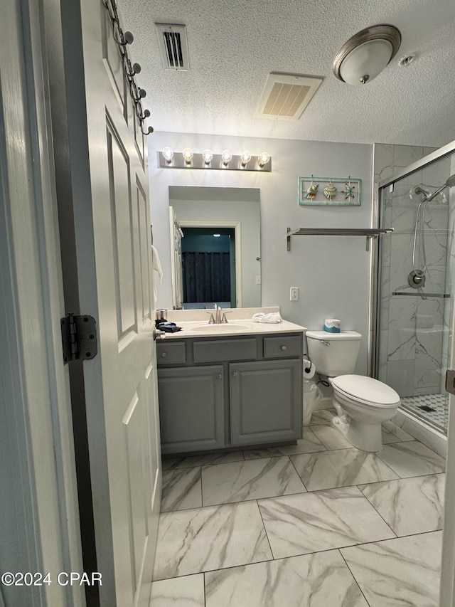 bathroom featuring a textured ceiling, vanity, an enclosed shower, and toilet