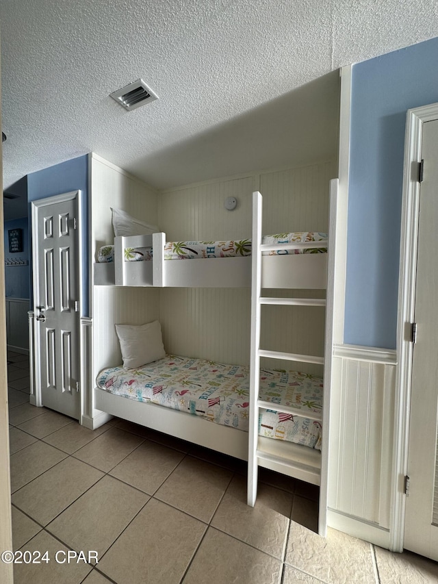 unfurnished bedroom with tile patterned flooring and a textured ceiling