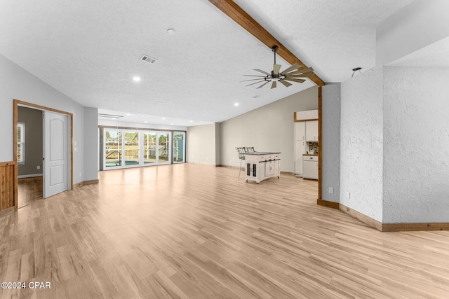 unfurnished living room with vaulted ceiling with beams, light hardwood / wood-style floors, a textured ceiling, and ceiling fan