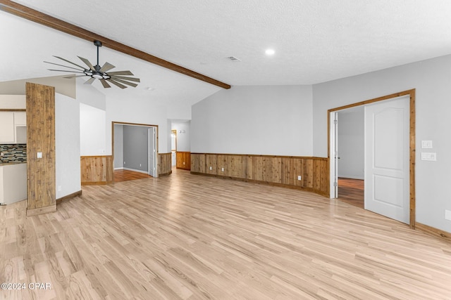 unfurnished living room featuring vaulted ceiling with beams, light hardwood / wood-style floors, a textured ceiling, and ceiling fan