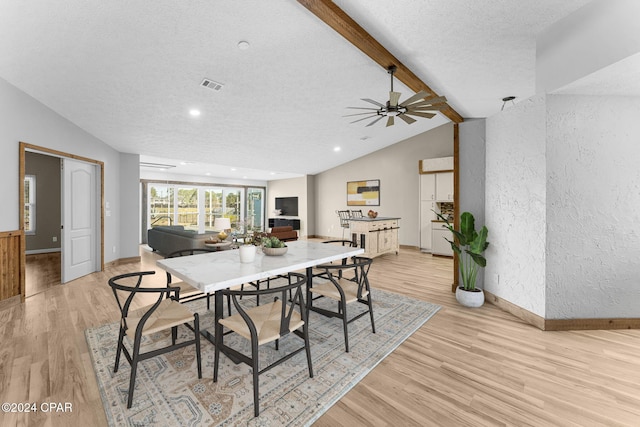 dining room featuring a textured ceiling, lofted ceiling with beams, light hardwood / wood-style flooring, and ceiling fan