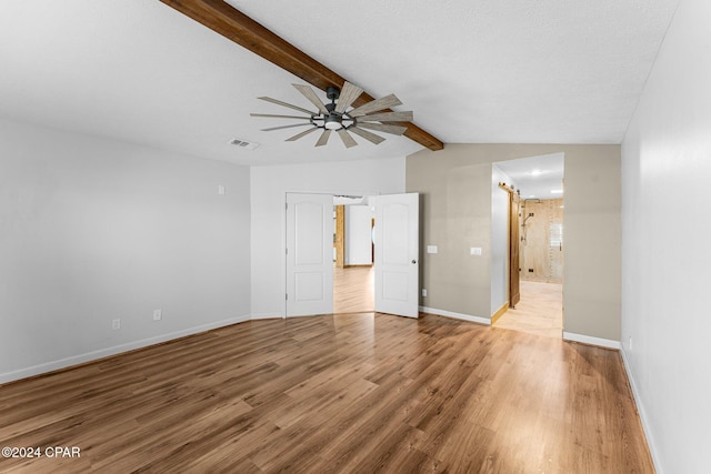 spare room featuring vaulted ceiling with beams, ceiling fan, and light hardwood / wood-style flooring