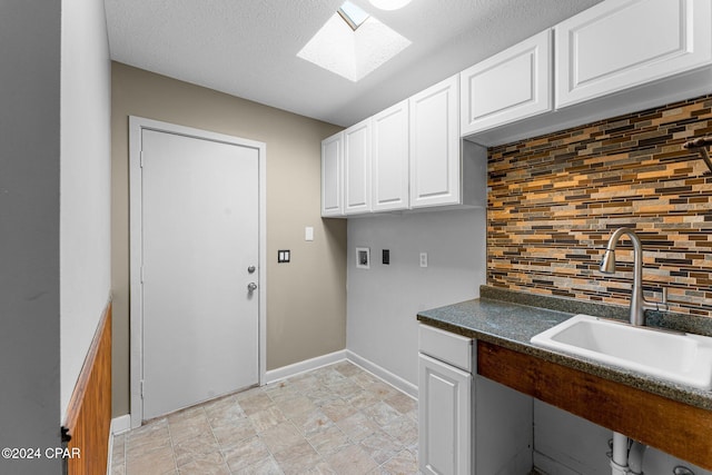 clothes washing area featuring washer hookup, a textured ceiling, a skylight, and sink