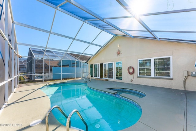 view of swimming pool featuring an in ground hot tub, a patio, and a lanai