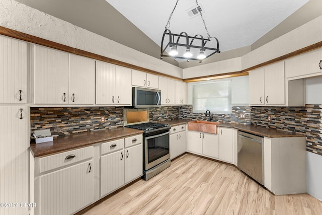 kitchen with white cabinetry, sink, vaulted ceiling, and appliances with stainless steel finishes