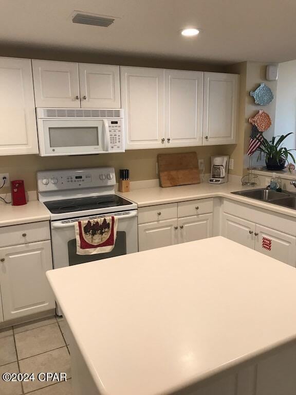 kitchen featuring white cabinetry, white appliances, sink, and light tile patterned floors