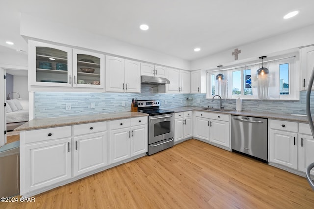 kitchen featuring white cabinetry, sink, pendant lighting, and appliances with stainless steel finishes