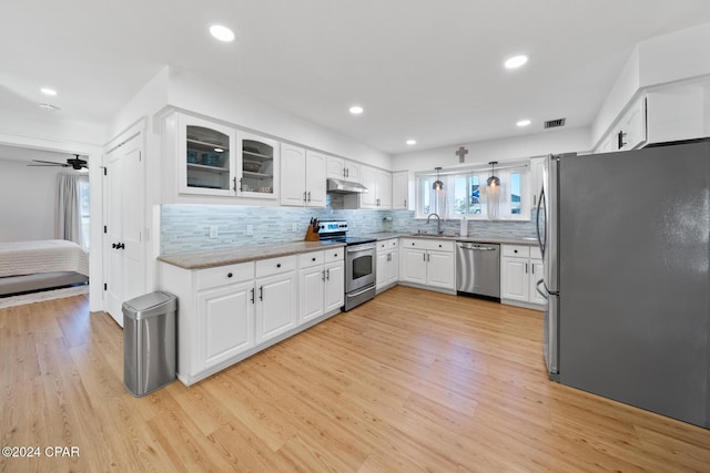 kitchen with pendant lighting, light hardwood / wood-style flooring, ceiling fan, appliances with stainless steel finishes, and white cabinetry