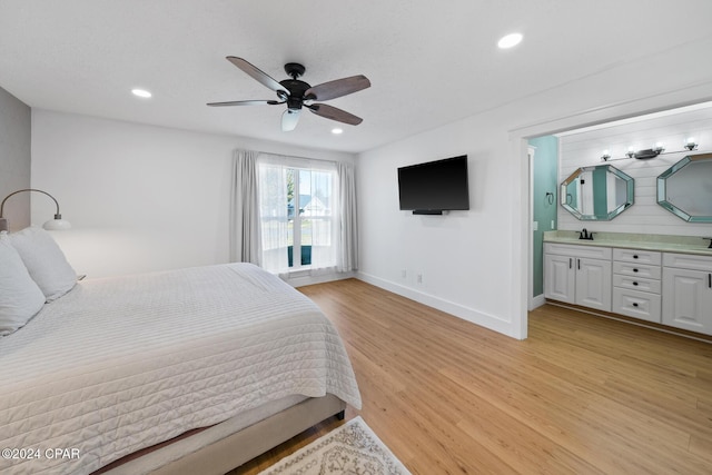 bedroom with connected bathroom, ceiling fan, sink, and light wood-type flooring