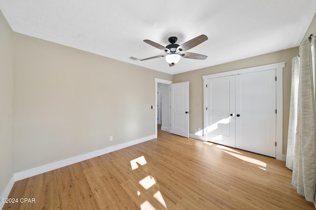 unfurnished bedroom featuring ceiling fan, a closet, and light hardwood / wood-style flooring