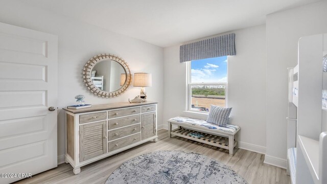 living area featuring light wood finished floors and baseboards