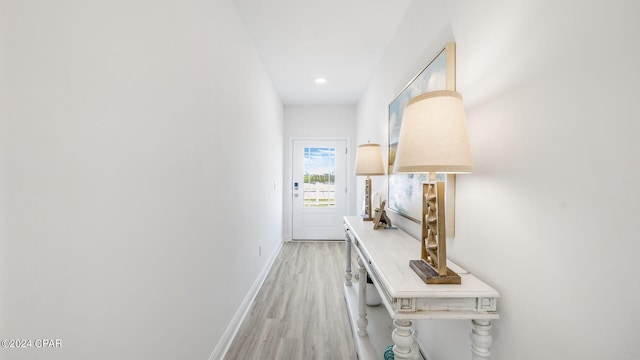 hall featuring light wood-type flooring and baseboards