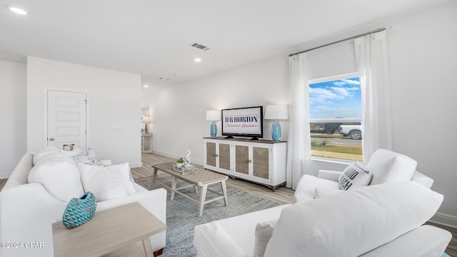 living room with visible vents, recessed lighting, baseboards, and wood finished floors