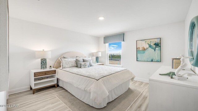 bedroom featuring light wood-style floors and baseboards