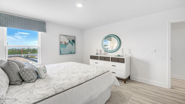 bedroom with light wood-type flooring and baseboards