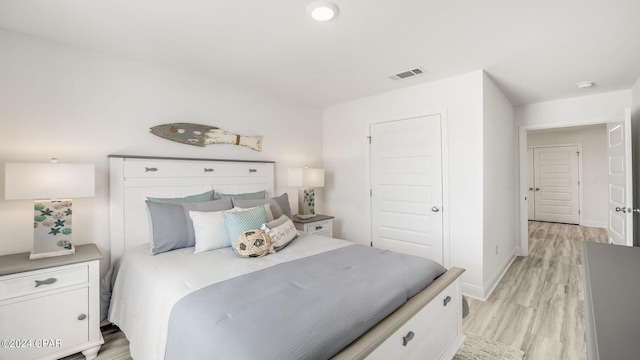 bedroom with light wood-style flooring, baseboards, and visible vents