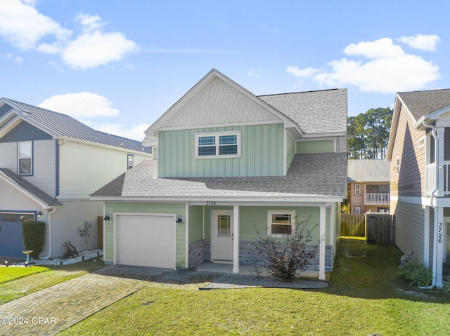 view of front of property with a garage, roof with shingles, decorative driveway, a front lawn, and board and batten siding