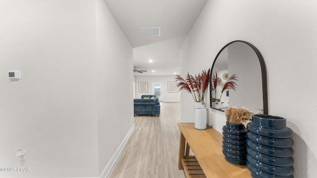 hallway with visible vents, baseboards, and light wood-style floors