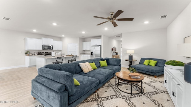 living room featuring recessed lighting, visible vents, and baseboards