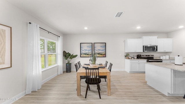 dining space with recessed lighting, light wood-style floors, and visible vents